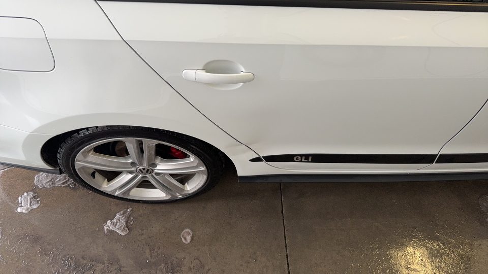 Volkswagen GLI restaurée avec une peinture neuve après un accident, alignement parfait des panneaux.